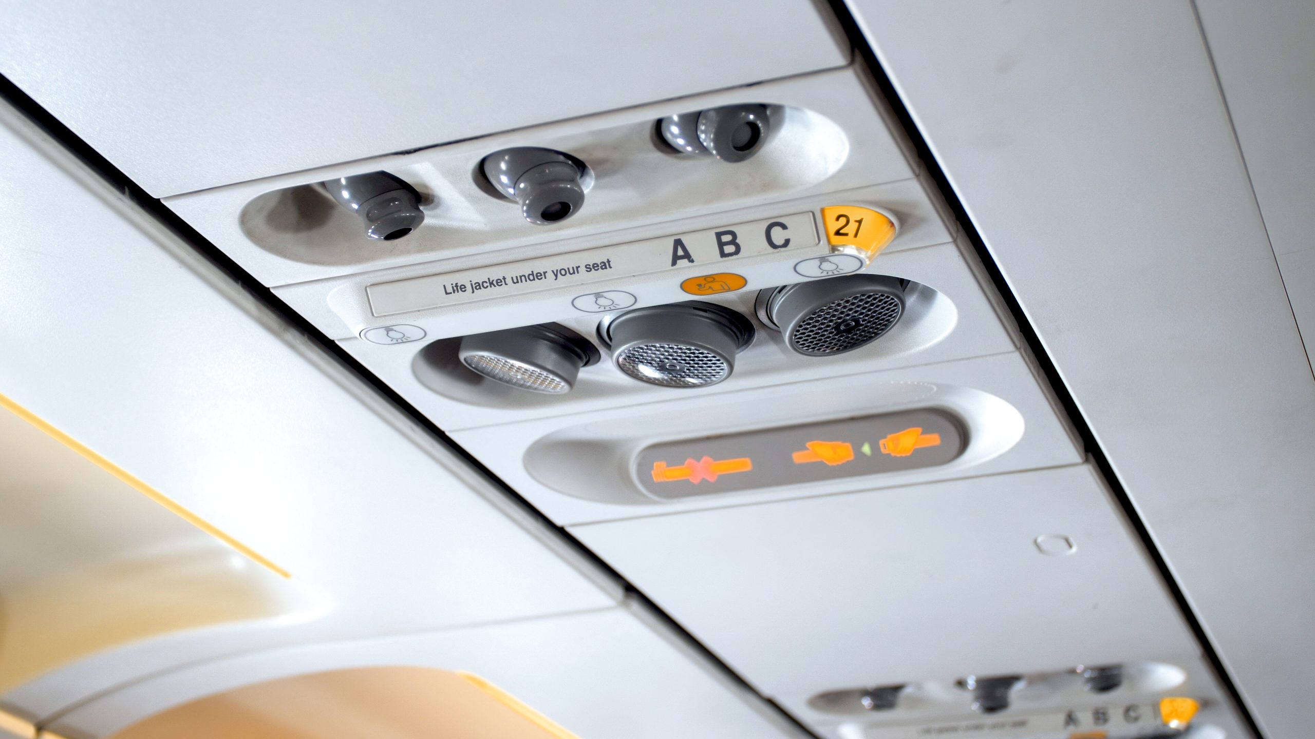 Closeup image of buttons and lights on the ceiling above the pasenger seat in airplane